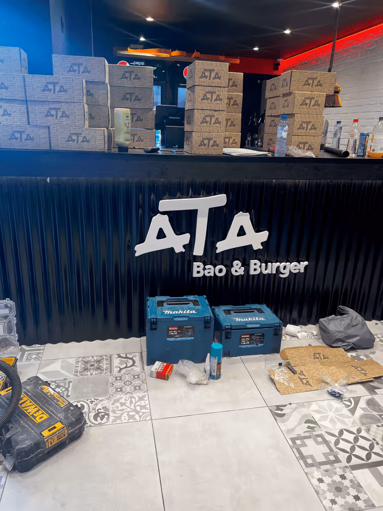 Vue intérieure Ata Bao Burger Ixelles avec calligraphie murale et lettres comptoir