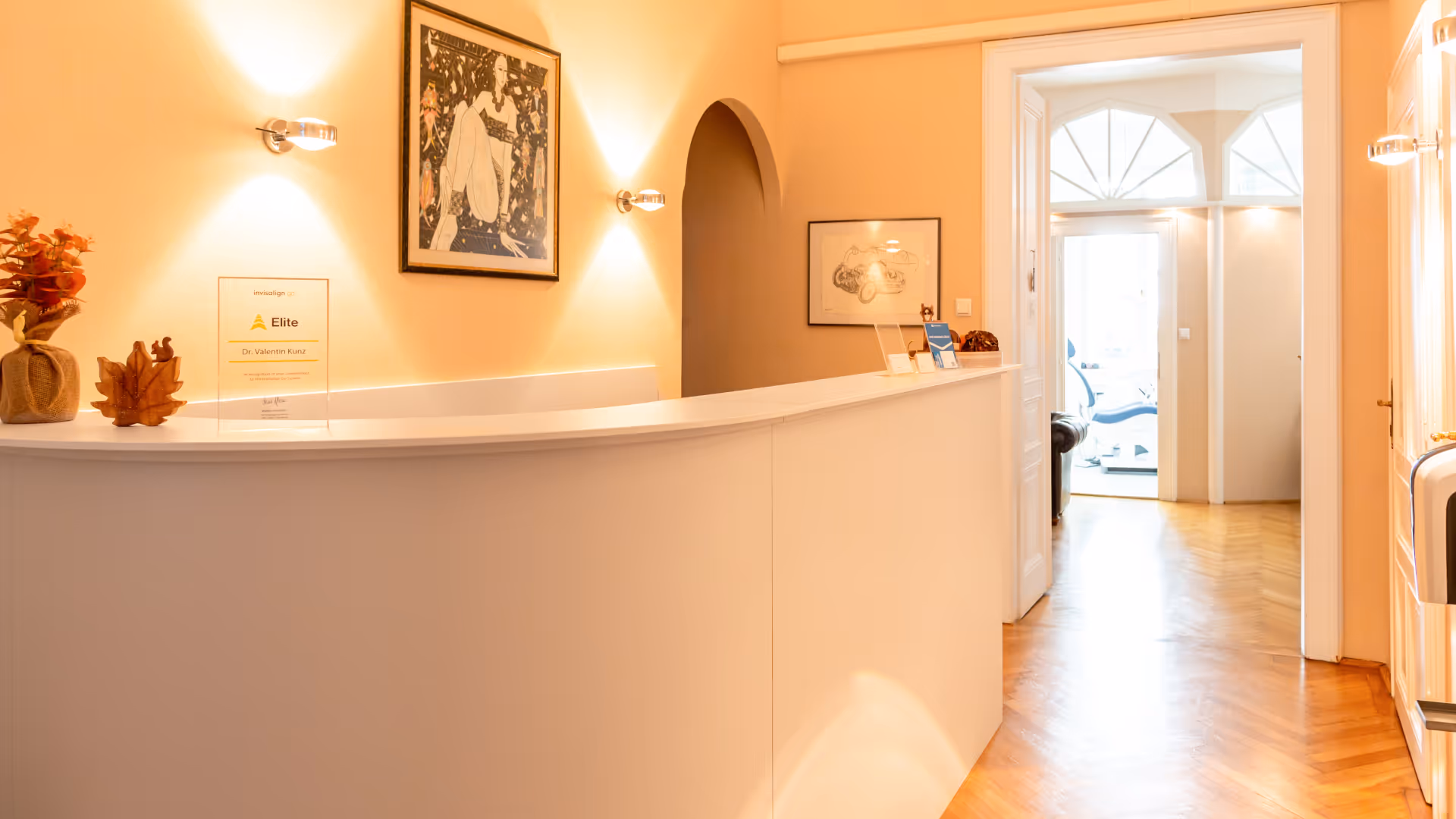 Moderne Zahnarztpraxis mit eleganter Rezeption und warmem Licht in Wien