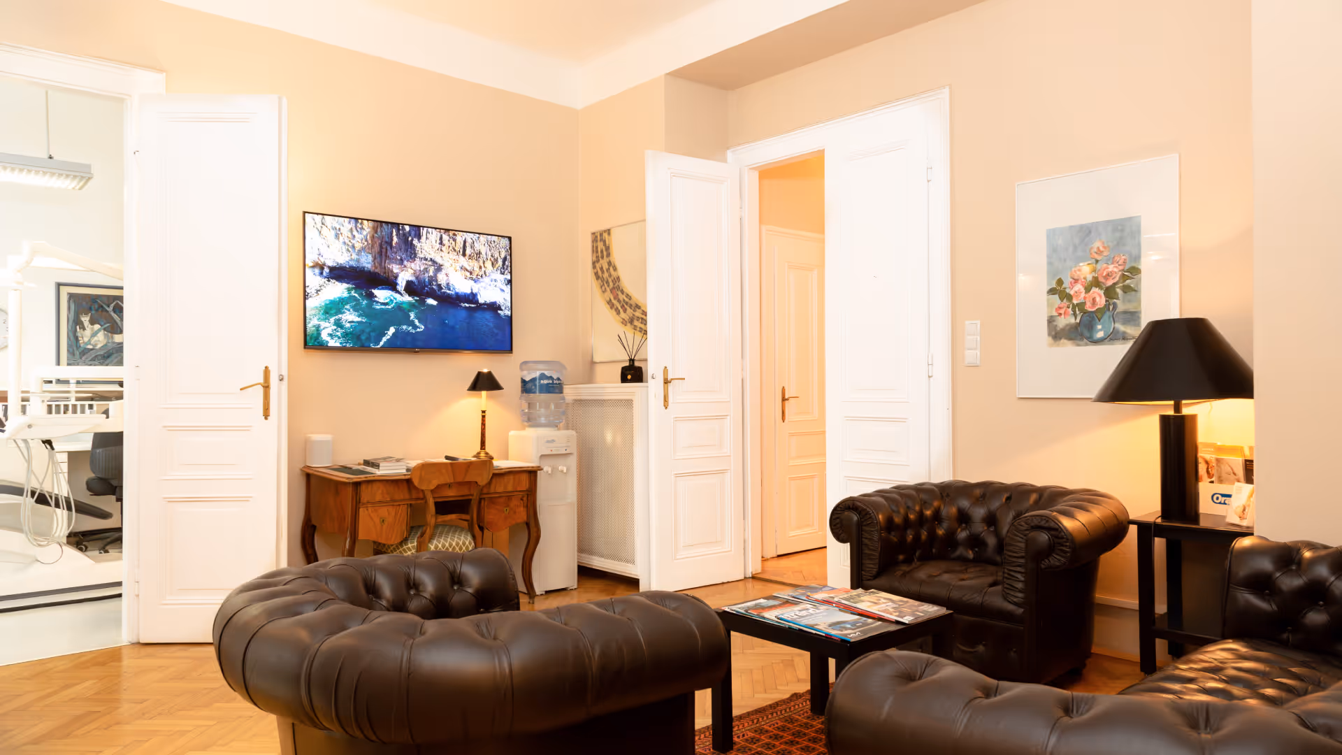 Gemütliche Praxislounge mit Chesterfield-Sesseln und Meereslandschaft