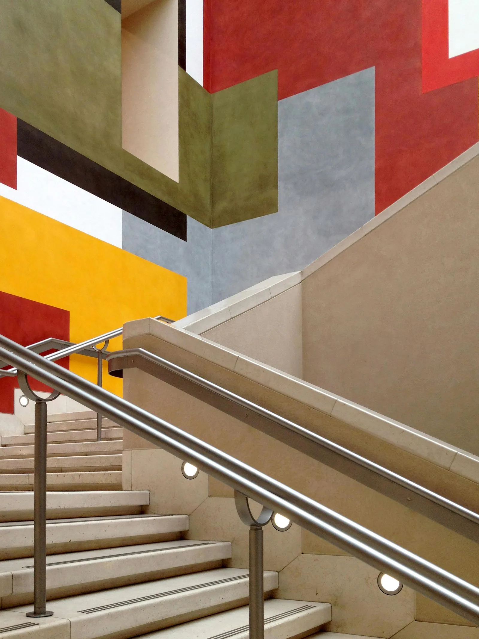 A modern staircase with colorful geometric wall art