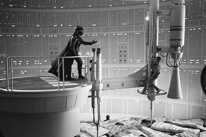 Scene from Star Wars showing Darth Vader reaching out toward Luke Skywalker hanging from a mechanical arm inside the Death Star.