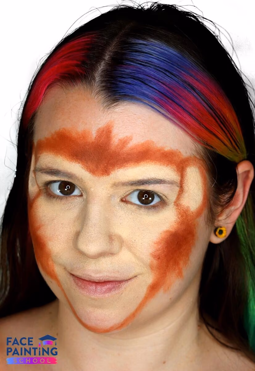 a smiling girl looking at the camera at an angle with a almost finished monkey face painting design