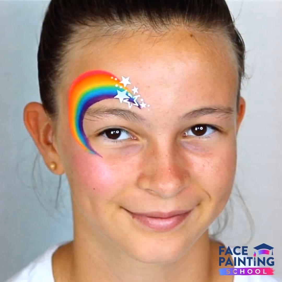 a girl with a rainbow face paint around her eye with added stars