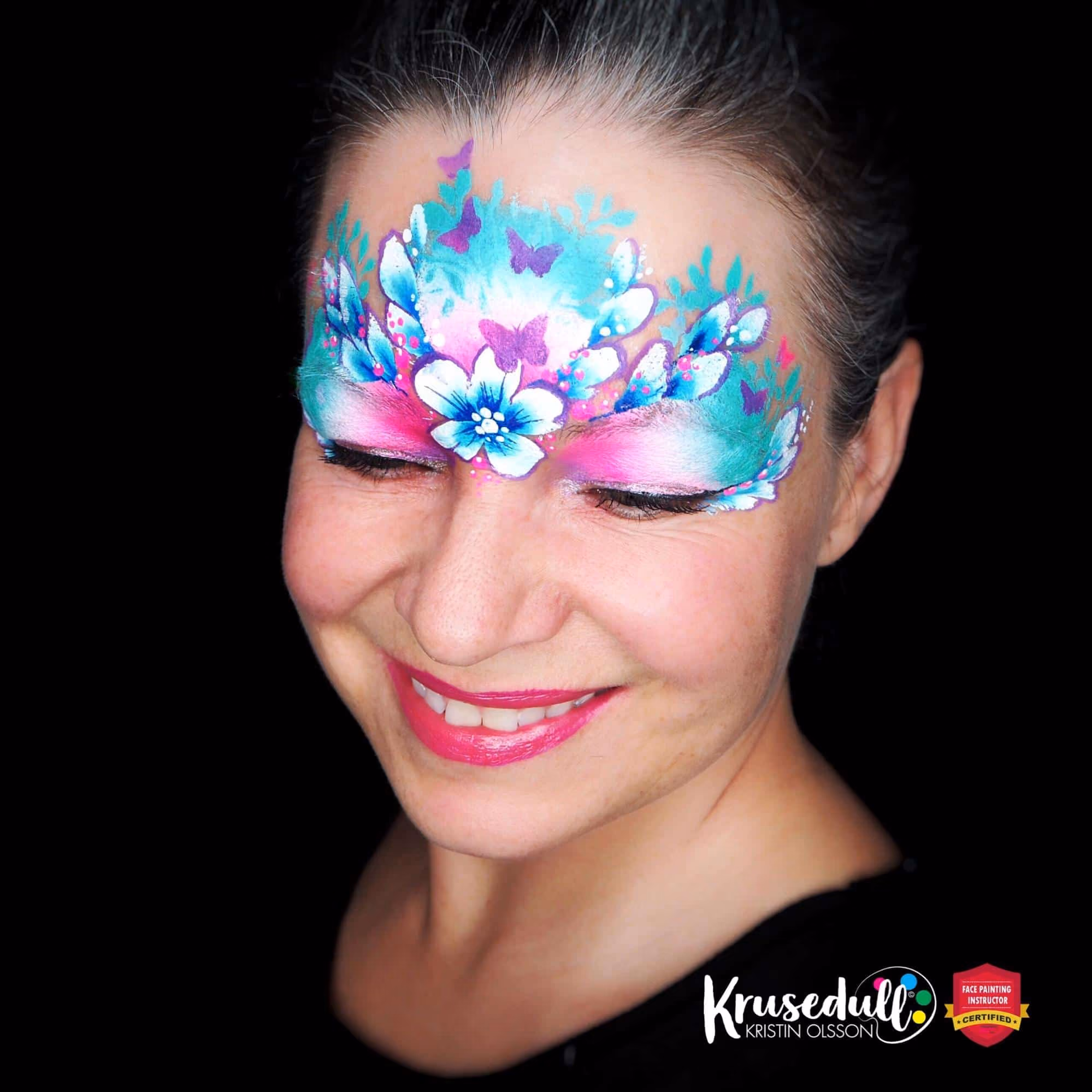 an image of a woman with a rose and blue flower and butterfly face paint design