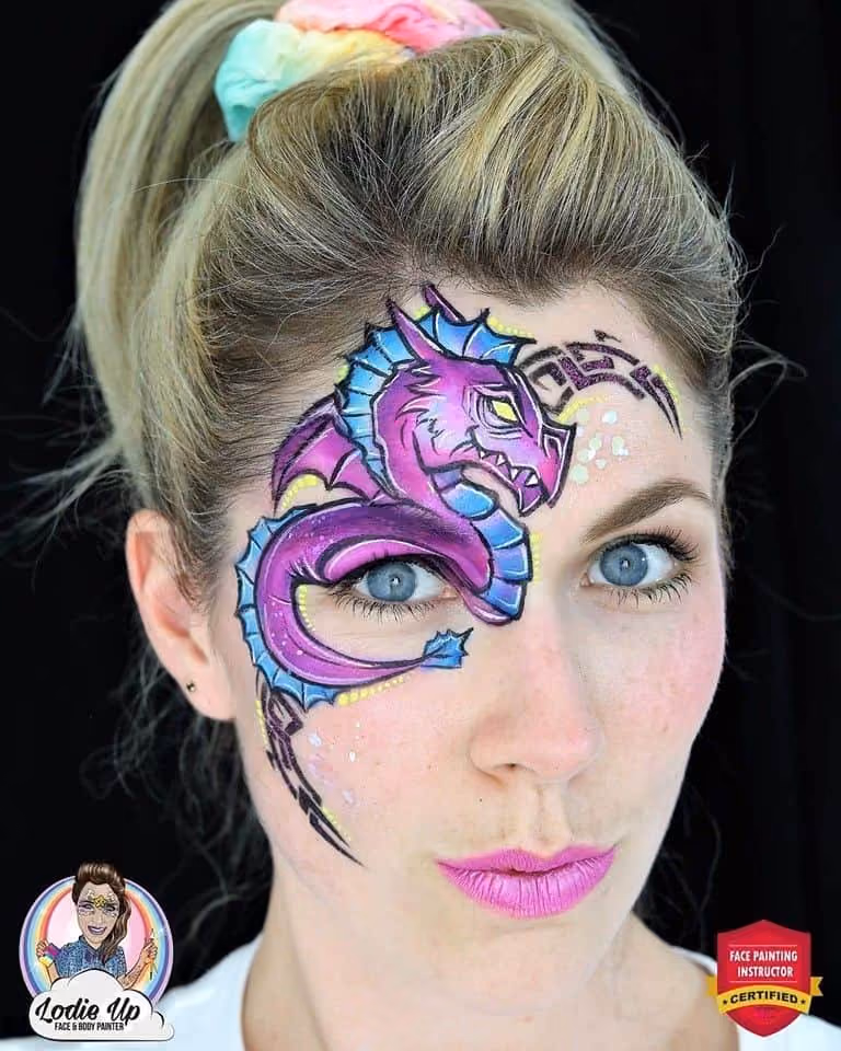 a woman with a purple dragon face paint desing