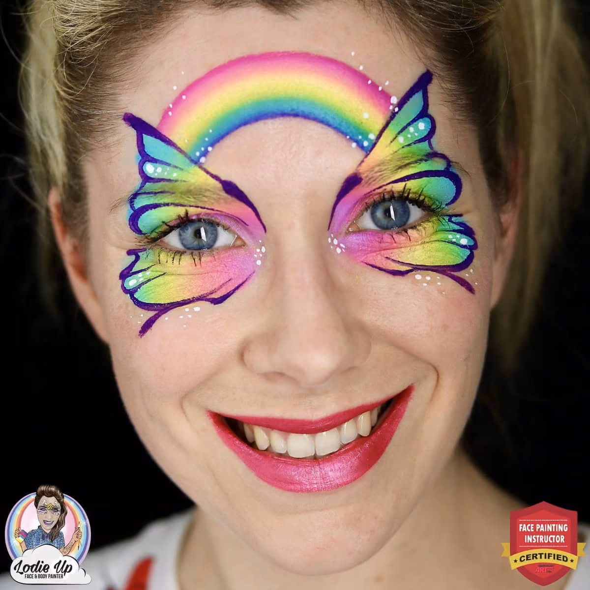 a woman with a compleated rainbow butterfly face paint design