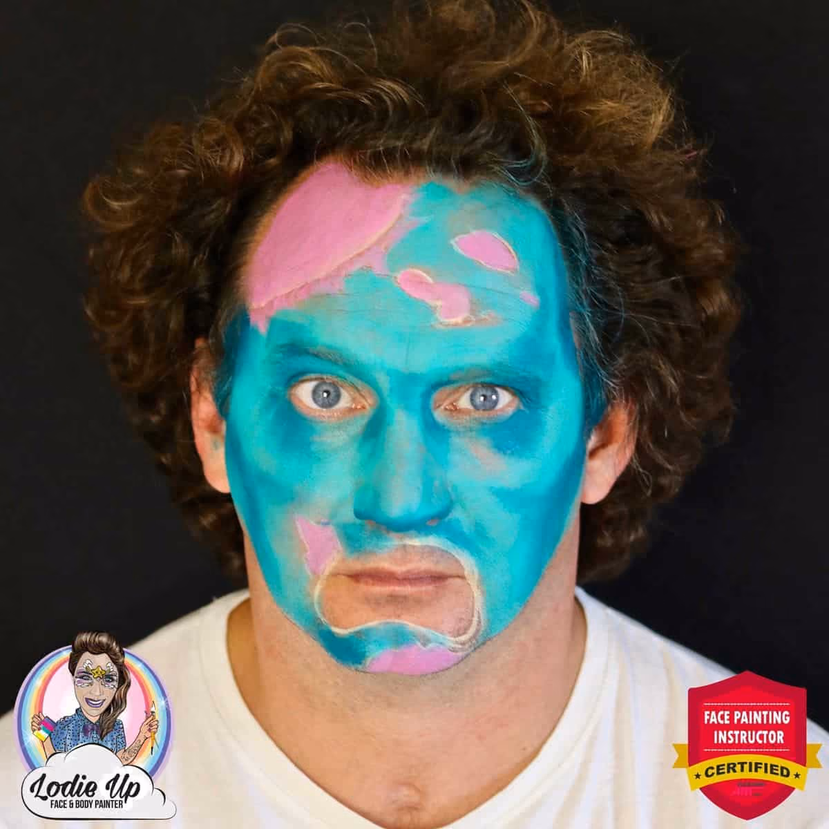 man looking at the camera with shading added to his colored zombie face paint