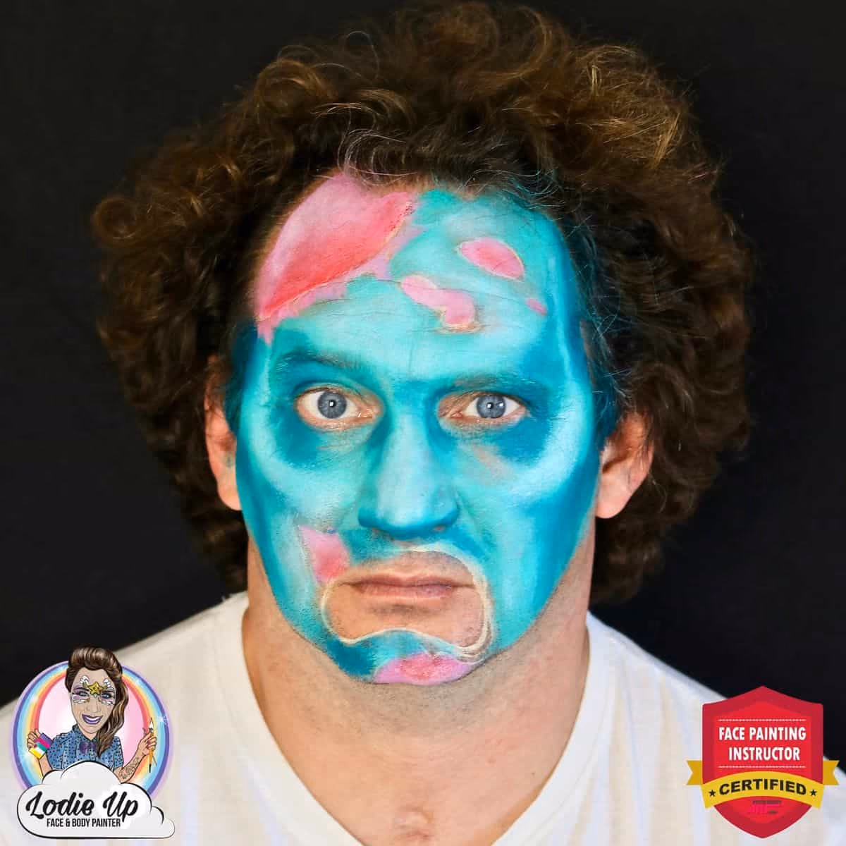 a man with shaded blue and pink face paint base for a zombie face paint design