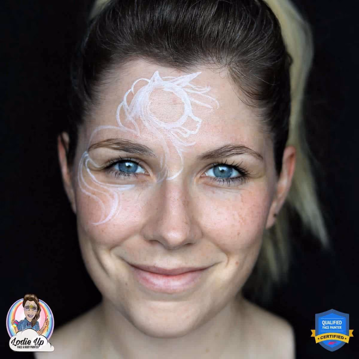 a woman with soft white outlines of a zombie unicorn face paint