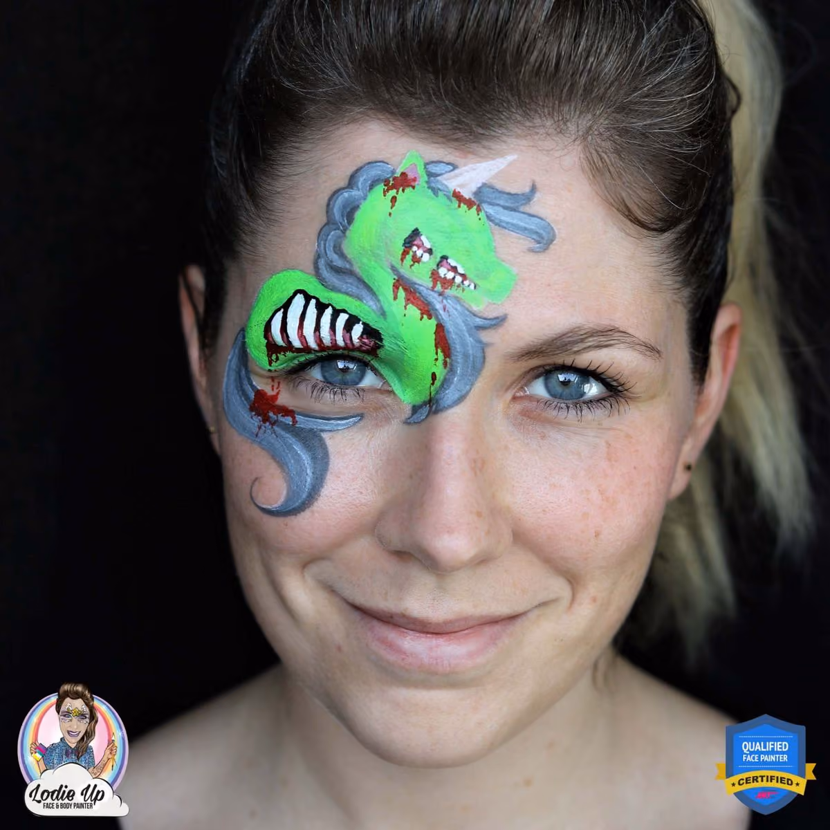 a girl looking at the camera with an unfinished design of a zombie unicorn face paint design