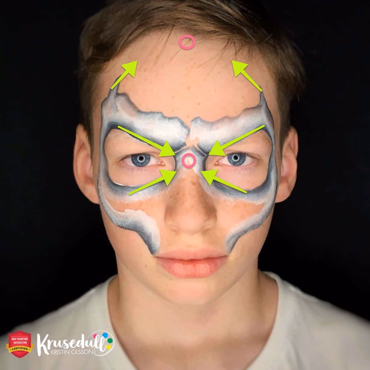 a boy with an uncomplete skull face paint with arrows that present focal points
