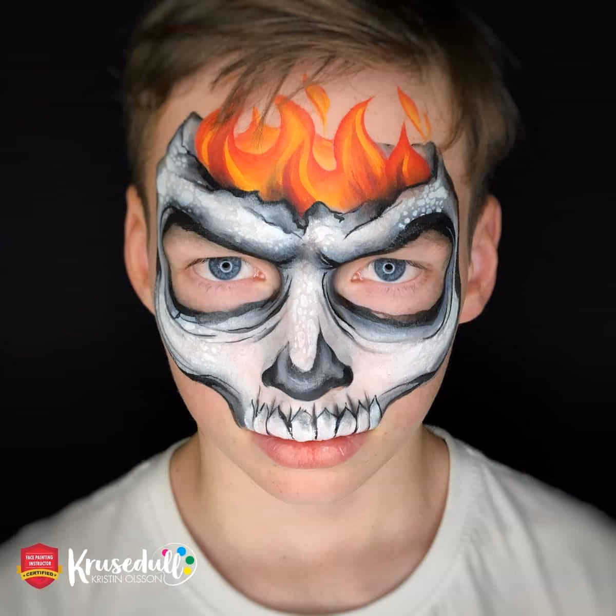 a boy with a complete skull face paint design