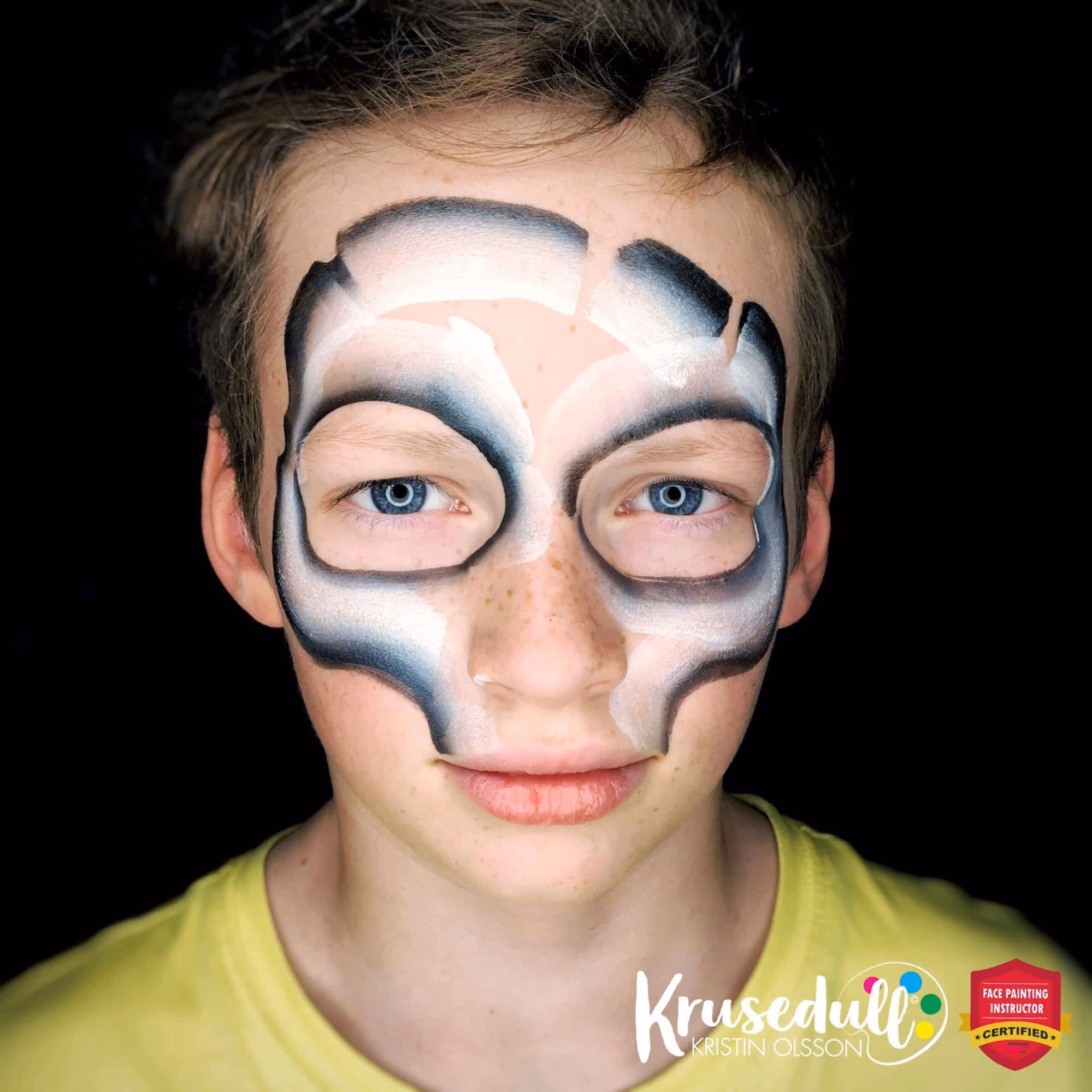 a boy with a skull mask face painting thats in the beginning stages of development