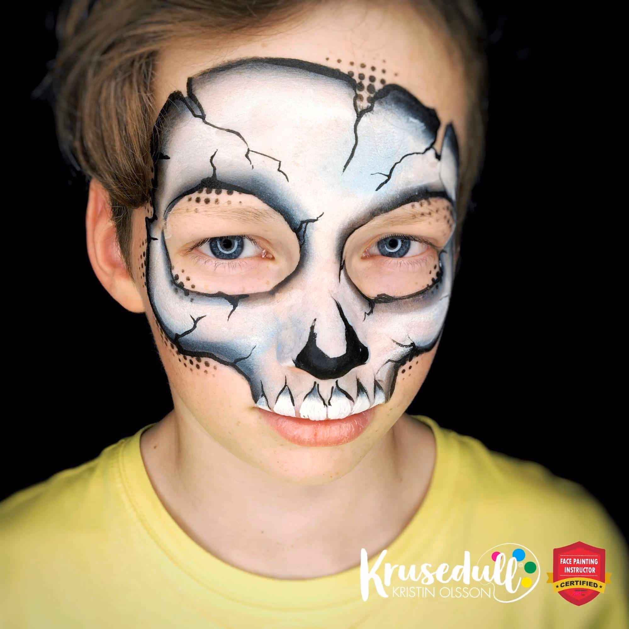 a boy with a compleated skull mask face paint design