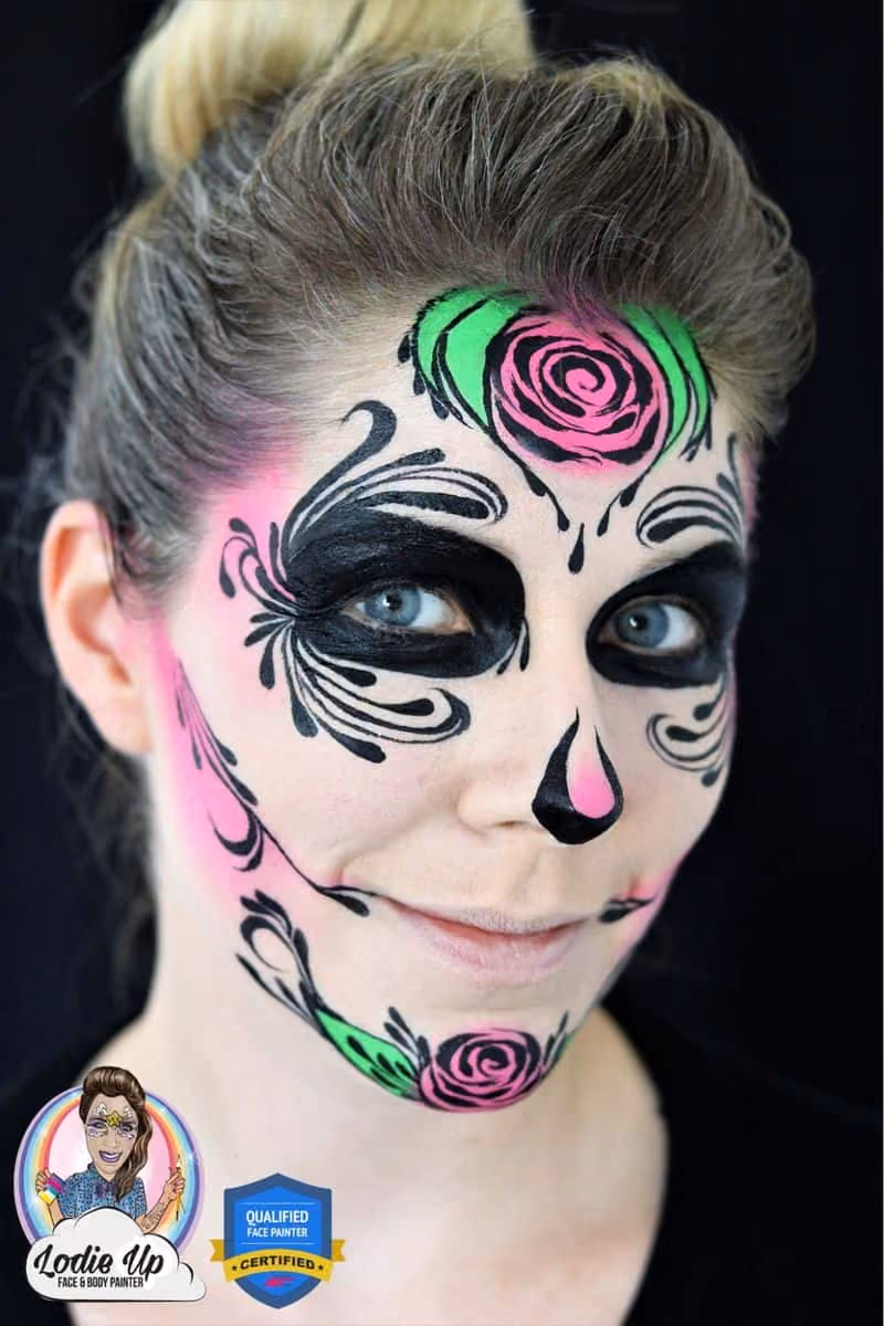 an image of a woman looking at the camera at an angle with a completed sugar skull face paint design