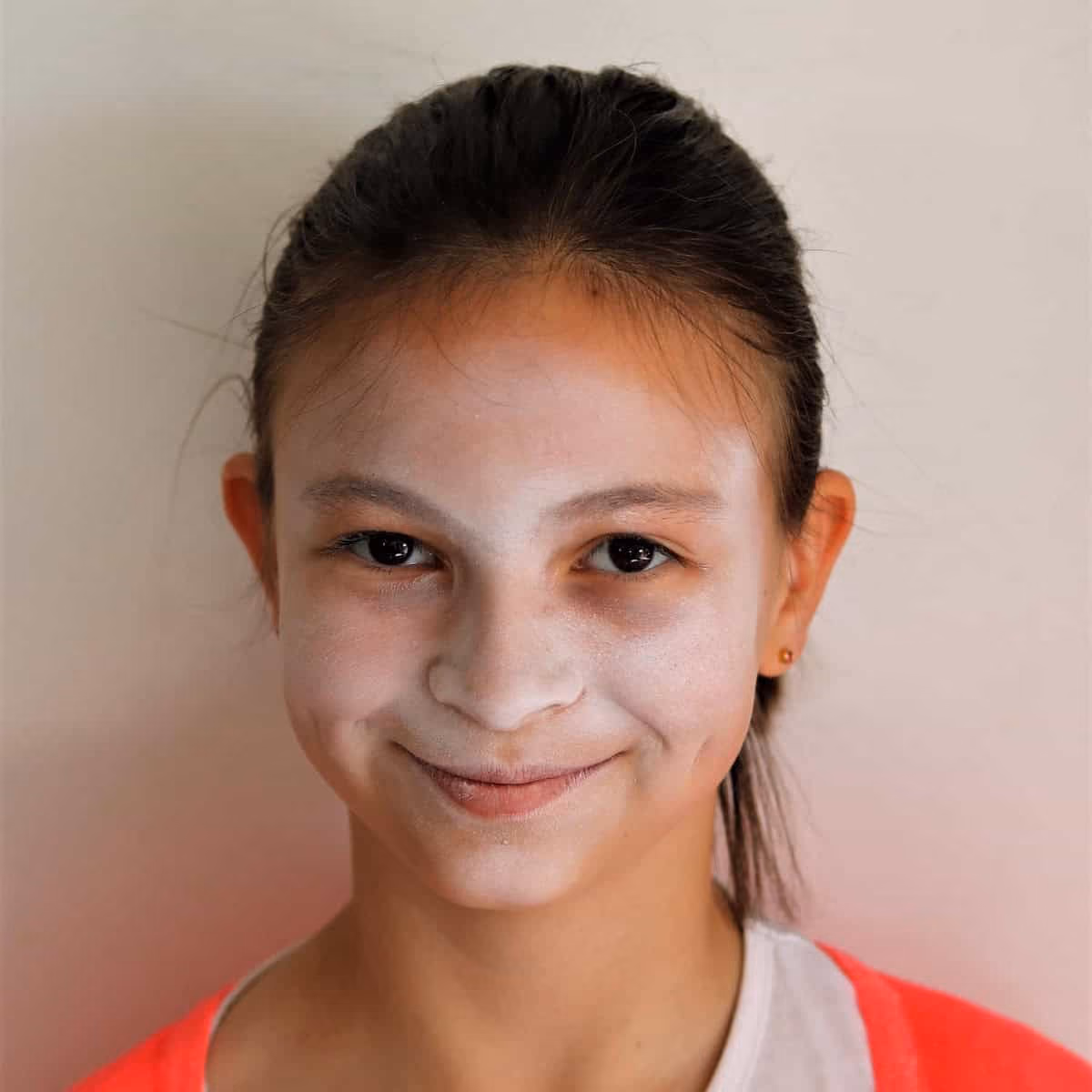 a girl with a skeleton face painting white colored base on her face