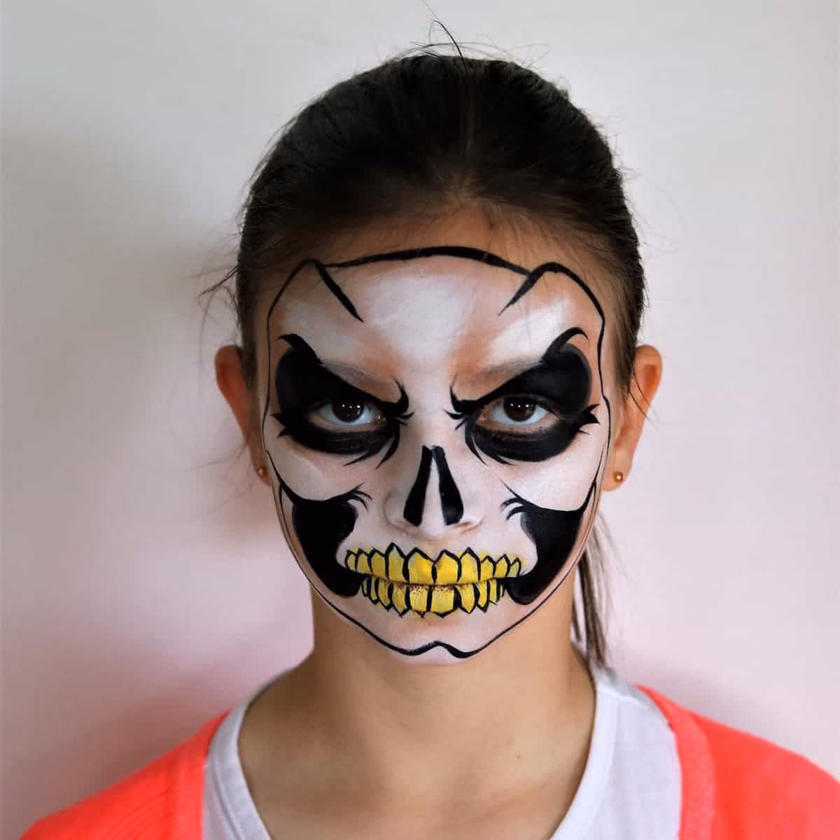 a girl with an angry looking skull face painting design