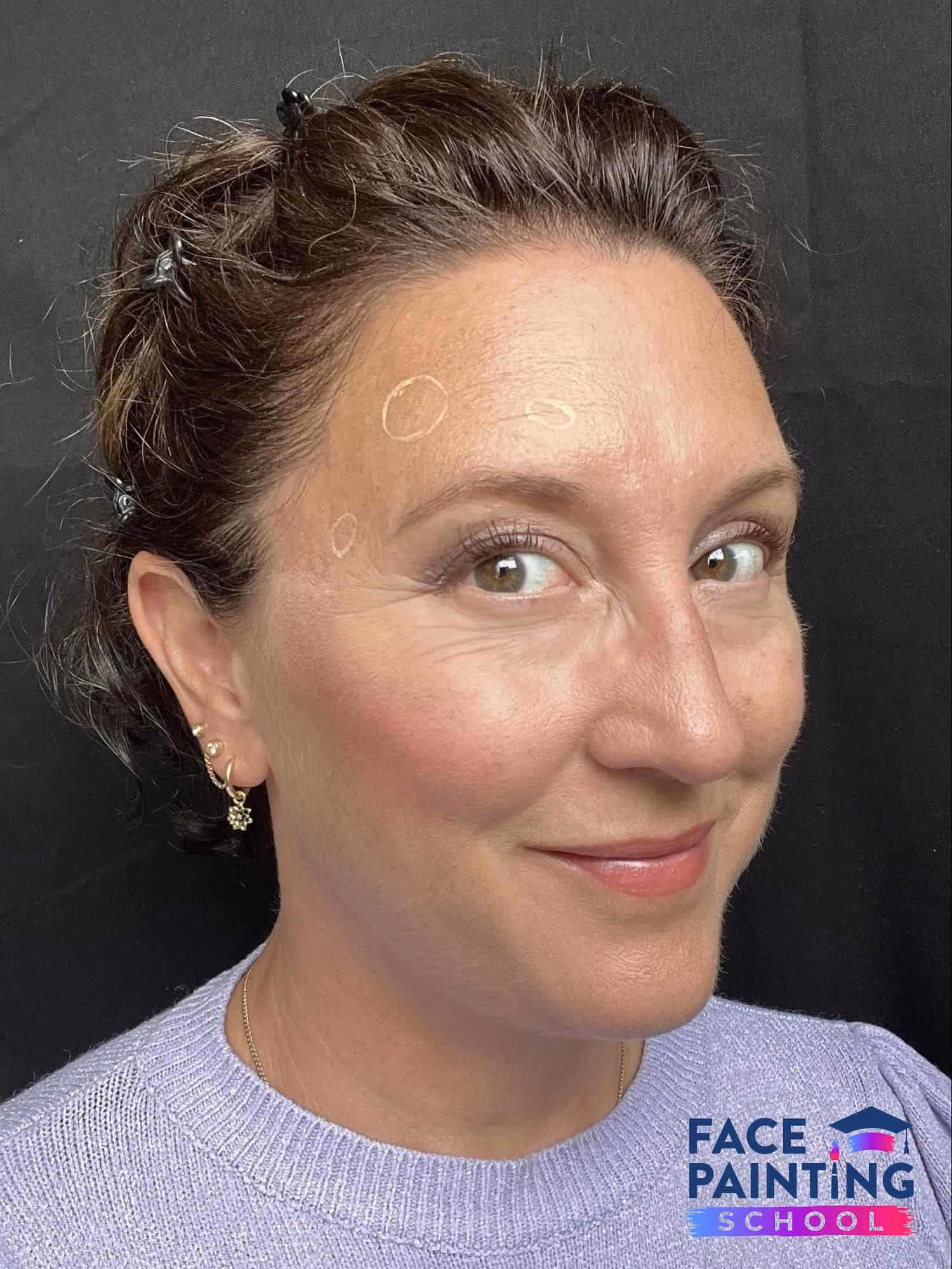 a woman looking at the camera with three circles on her face