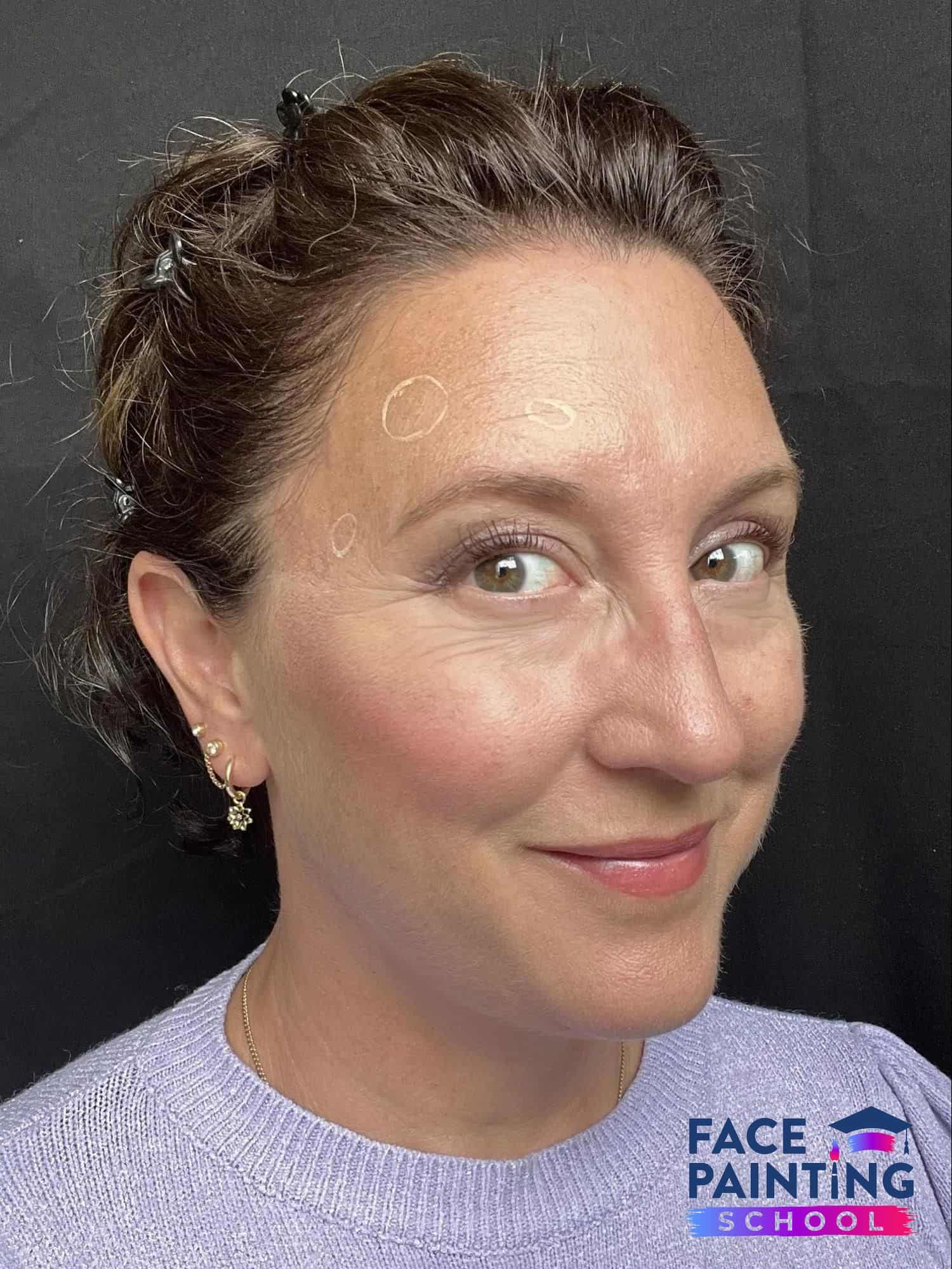 a woman looking at the camera with three circles on her face