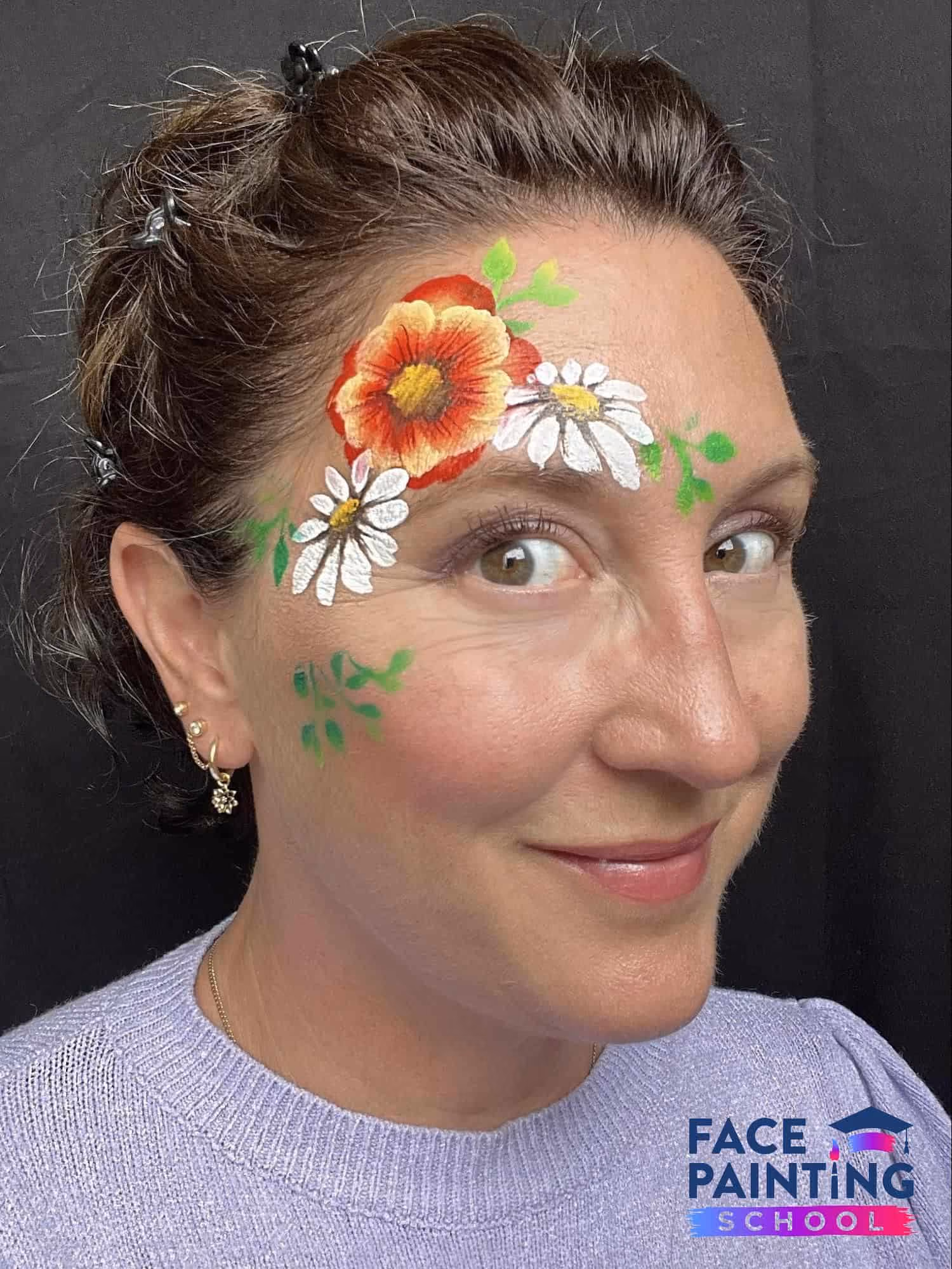 woman looking into the camera with three flowers painted on her face