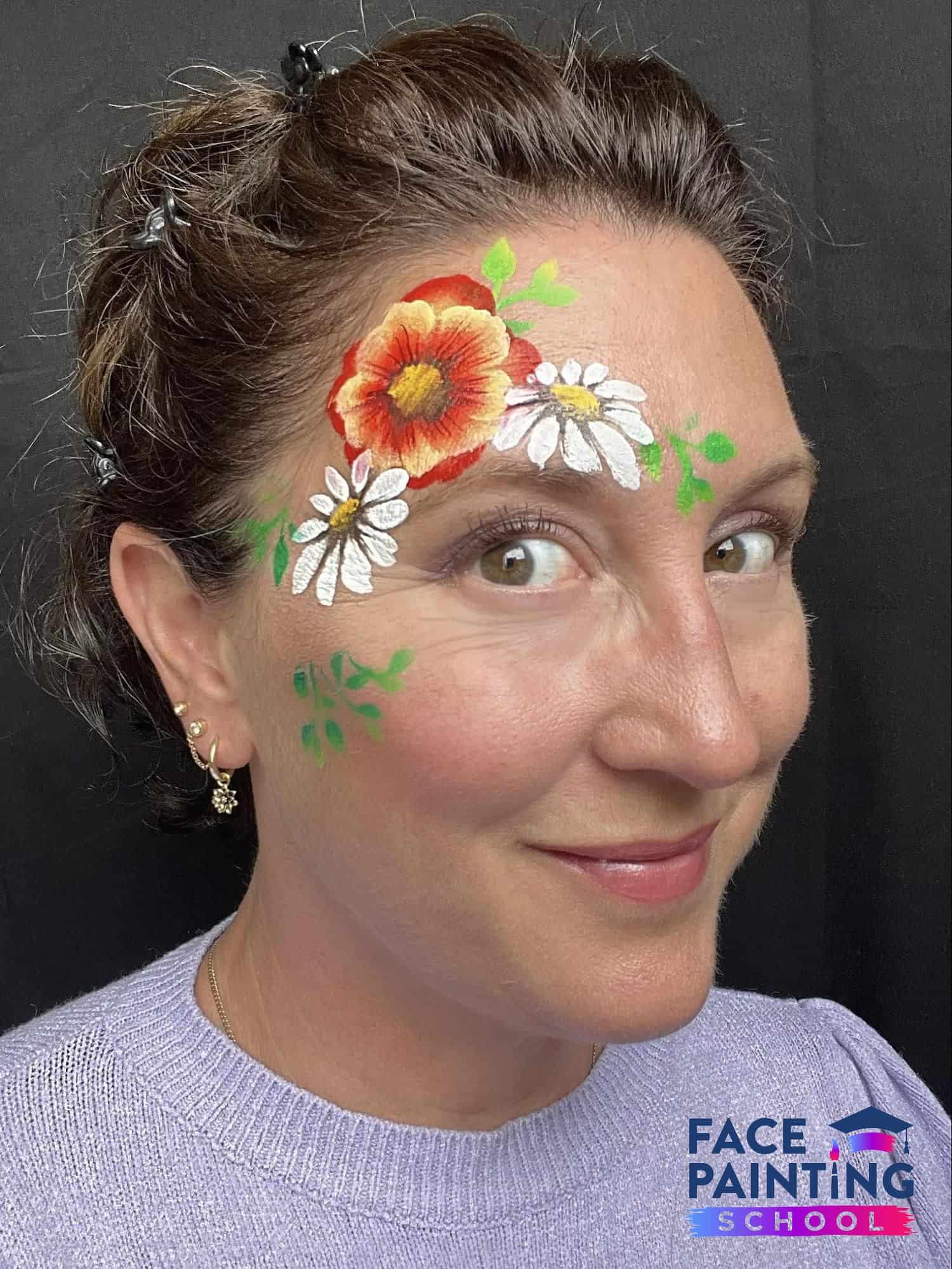 woman looking into the camera with three flowers painted on her face