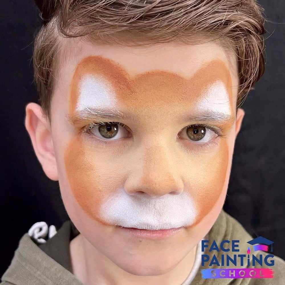 a boy with a base outline of a cheetah face paint design on his face