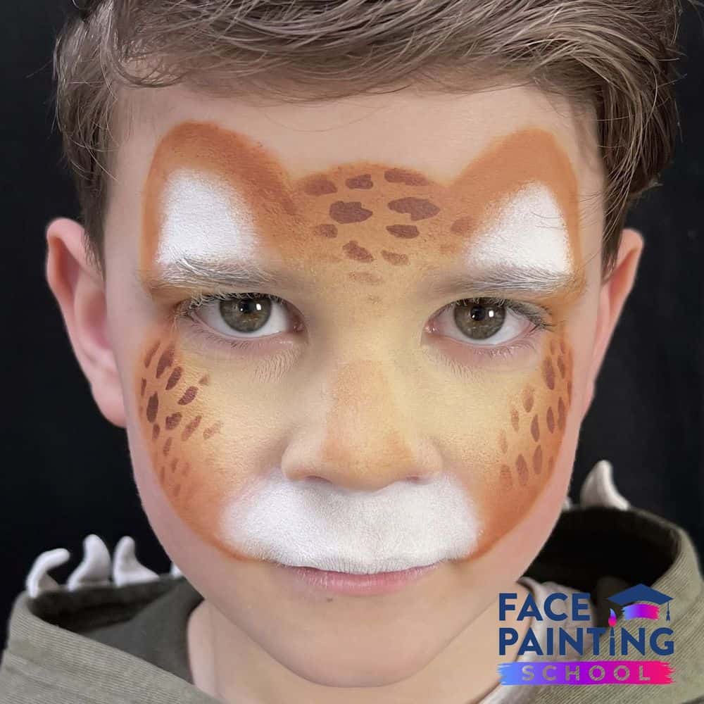 a boy with a cheetah face paint base on him