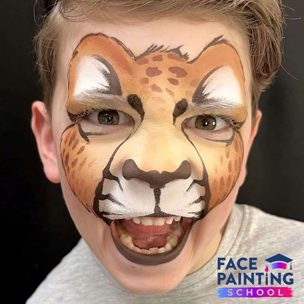 a boy roaring with a compleated cheetah face paint design