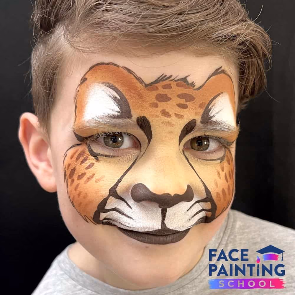 a boy with a finished cheetah face paint design on him