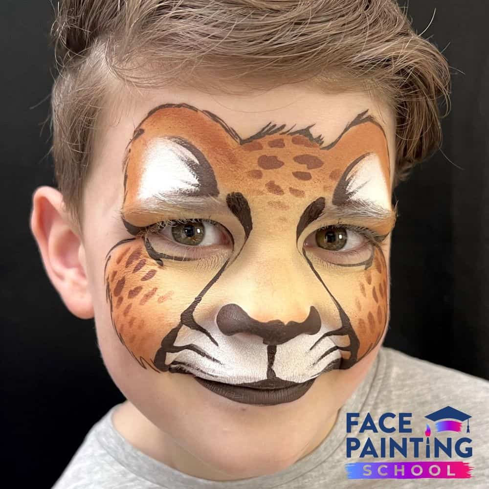 a boy with a finished cheetah face paint design on him