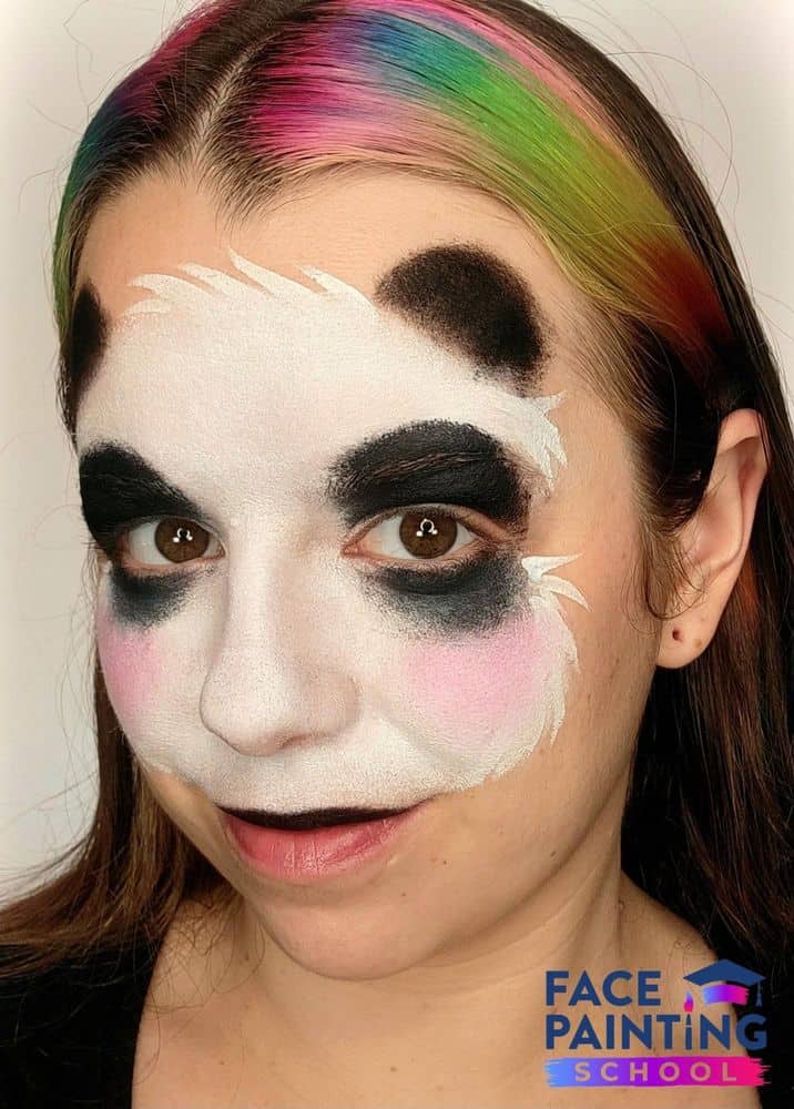 a girl with a panda face painting base now with two black ears