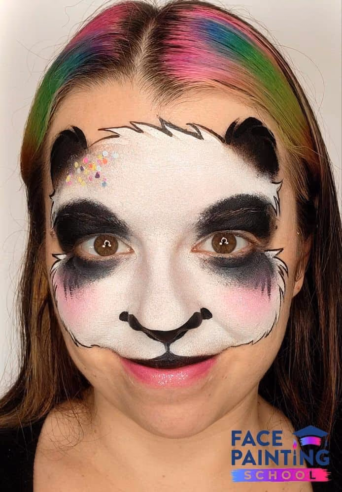 a girl with an outlined panda face painting