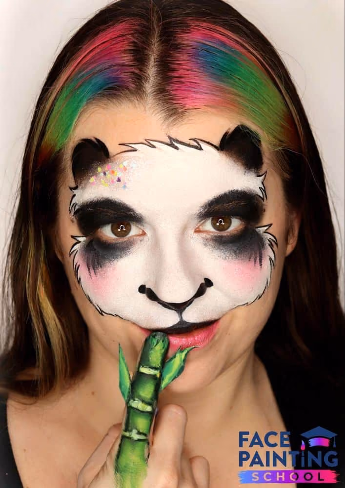 a girl wearing a compleated panda face paint design
