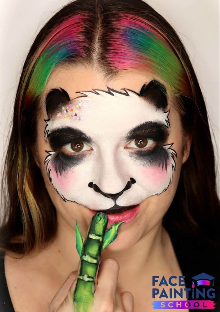 a girl wearing a compleated panda face paint design