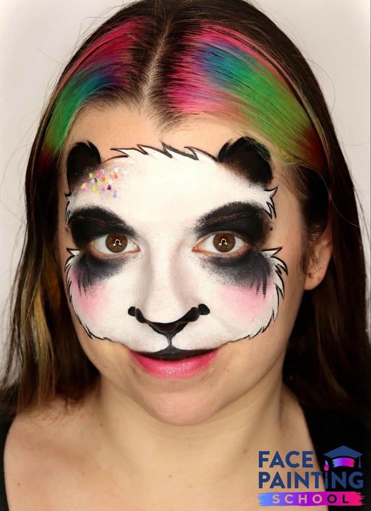 a girl with an compleated panda face paint design