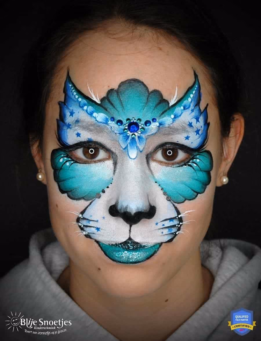 girl with a completed blue kitty cat face paint with her eyes open