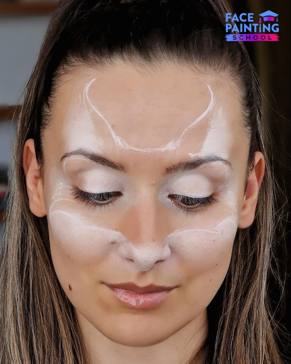 a girl with a slighltly filled white outline of a fox face pace paint design