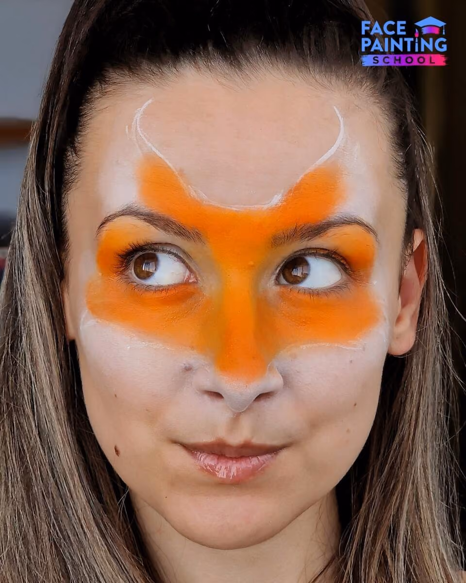 a girl with a fully orange filled outline of a fox face pace paint design