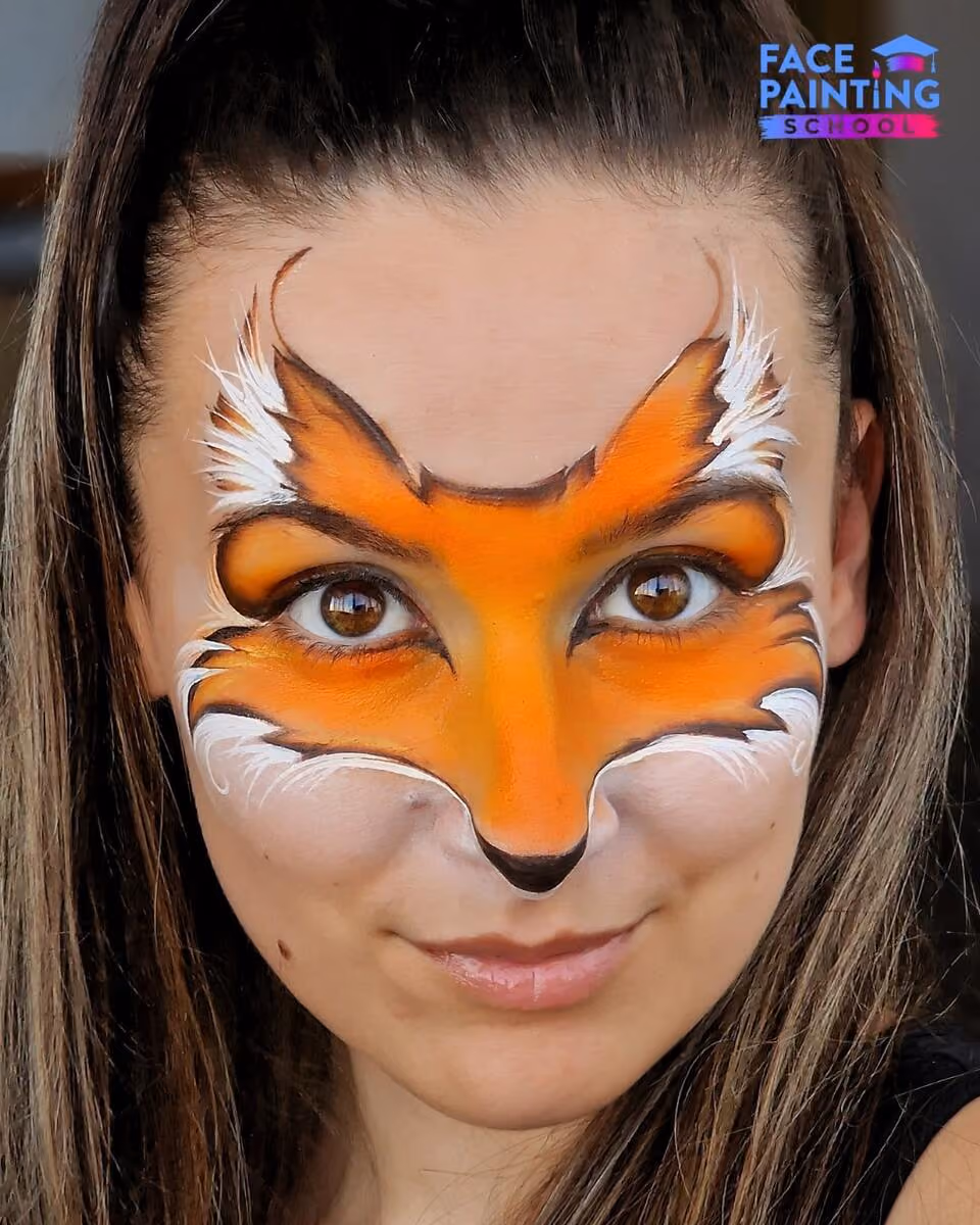 a girl with an almost finished fox face paint design