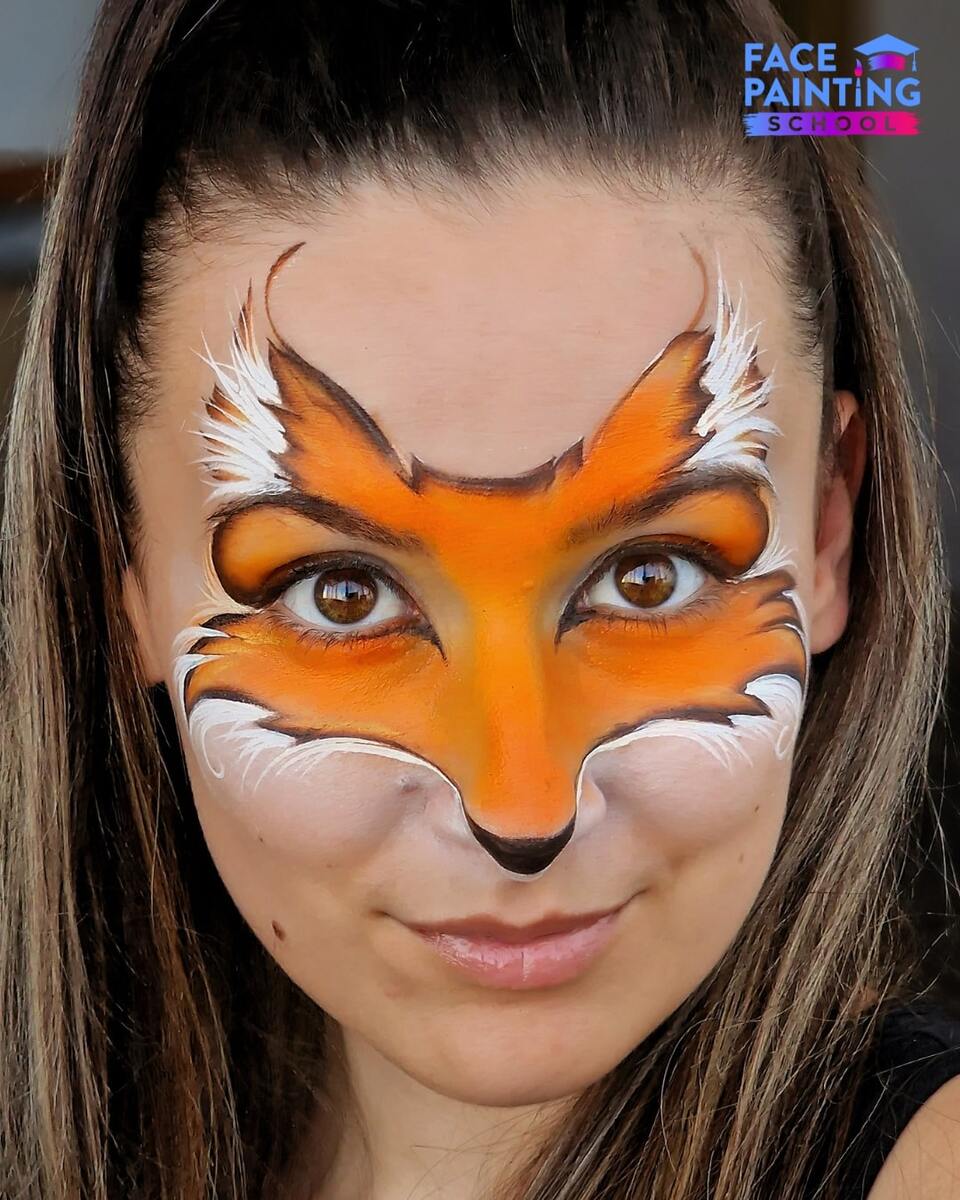 a girl with an almost finished fox face paint design