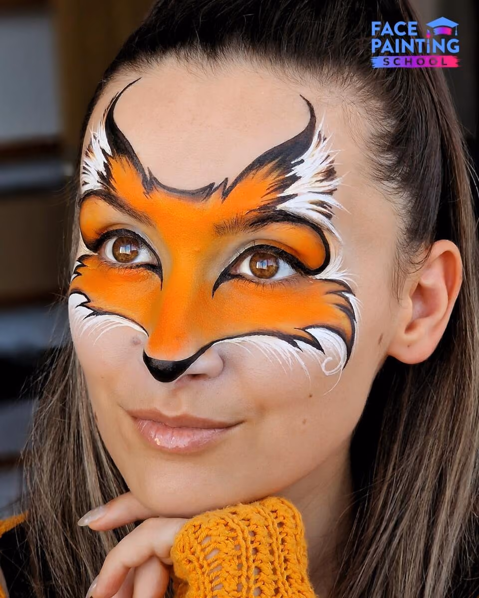 a girl posing for a photo with a fox face paint design