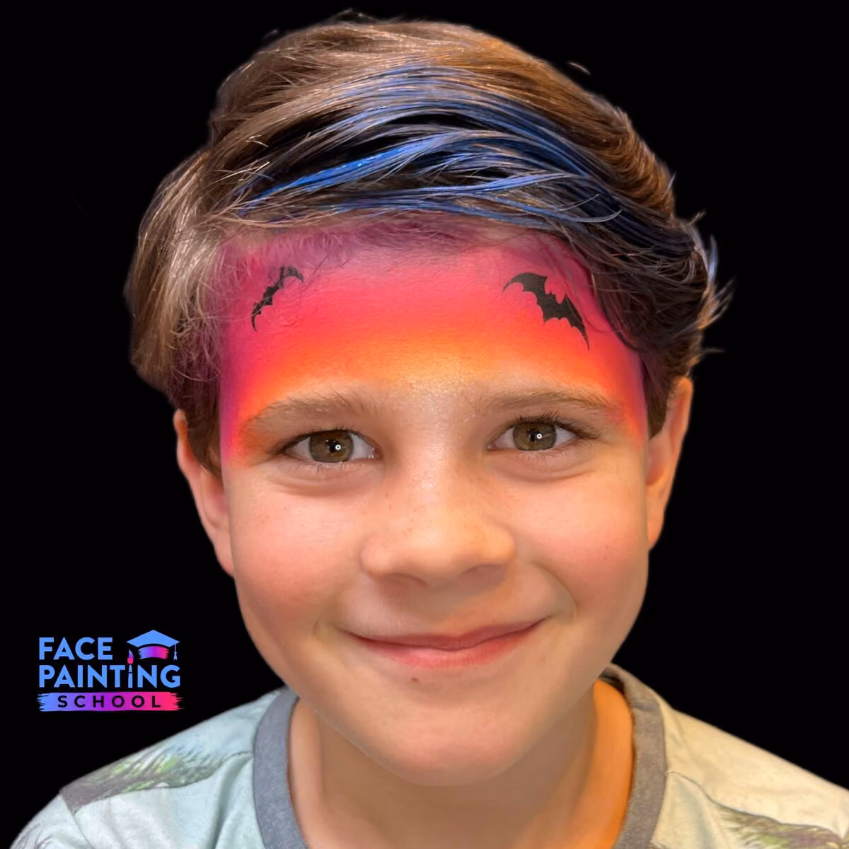 a boy with gradient red to yellow face paint on his forehead and two bats painted