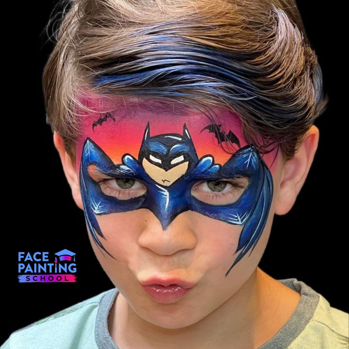 boy with a batman mask face paint over his face looking at the camera with his head slightly nodded