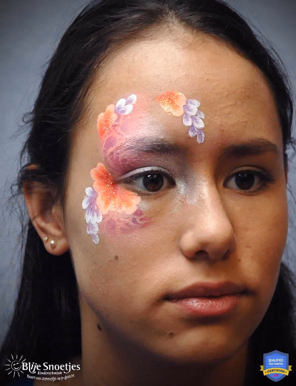 a woman looking at an angle with an unfinished fancy eye face paint design