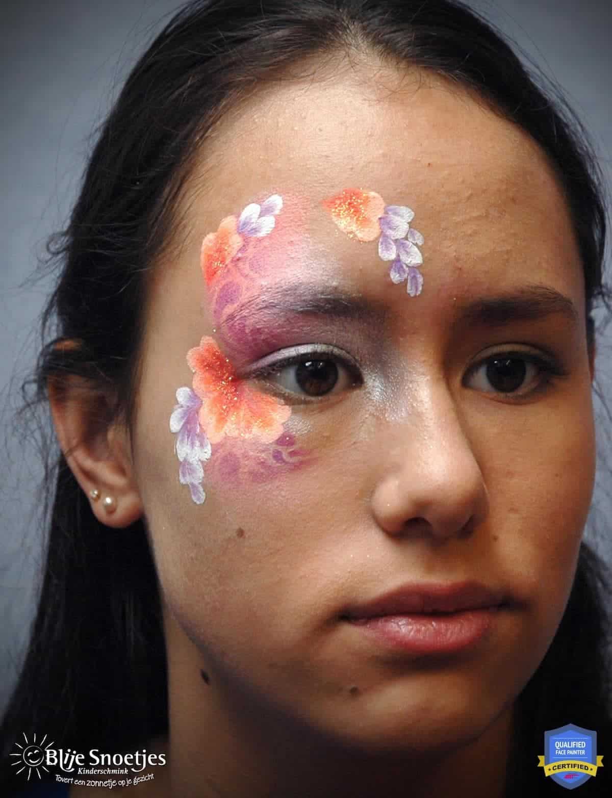 a woman looking at an angle with an unfinished fancy eye face paint design