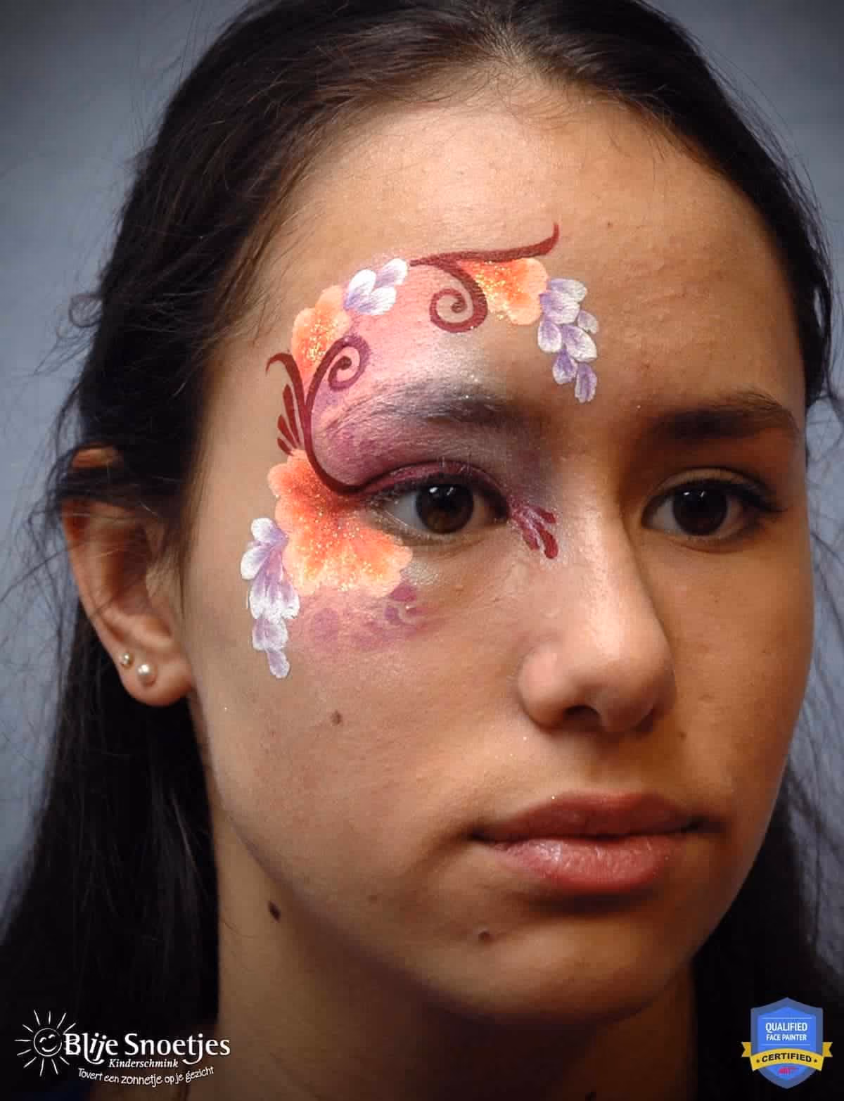 a woman looking at an angle with a compleated fancy eye face paint design