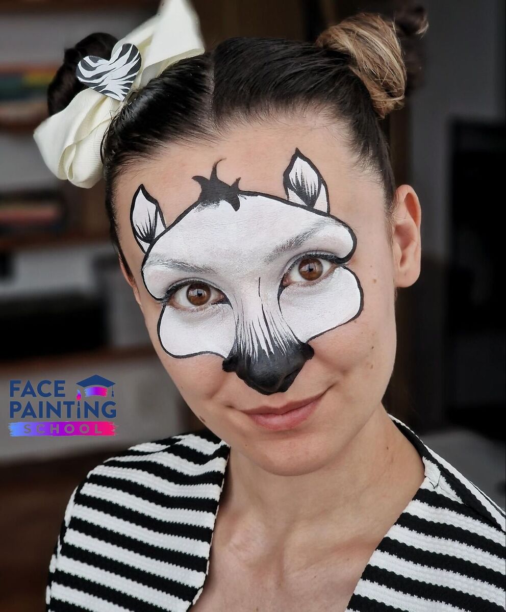 a woman with a zebra face paint with details on the ears but without stripes