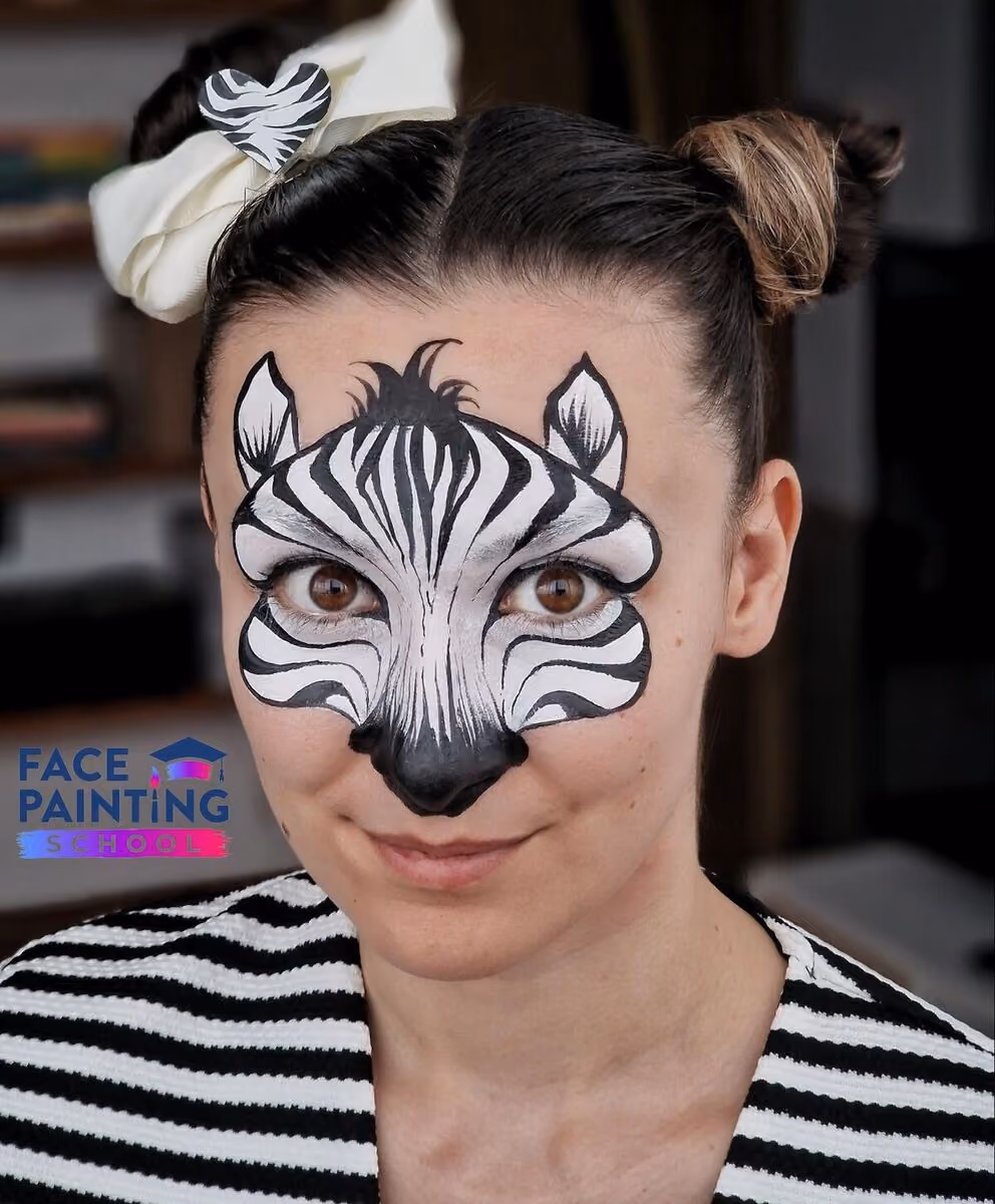 a portrait shot of a woman with a zebra face paint design on her face