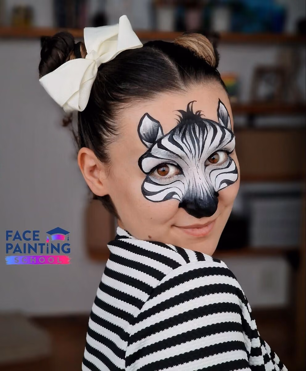 a woman posing with a compleated zebra face paint design on her face