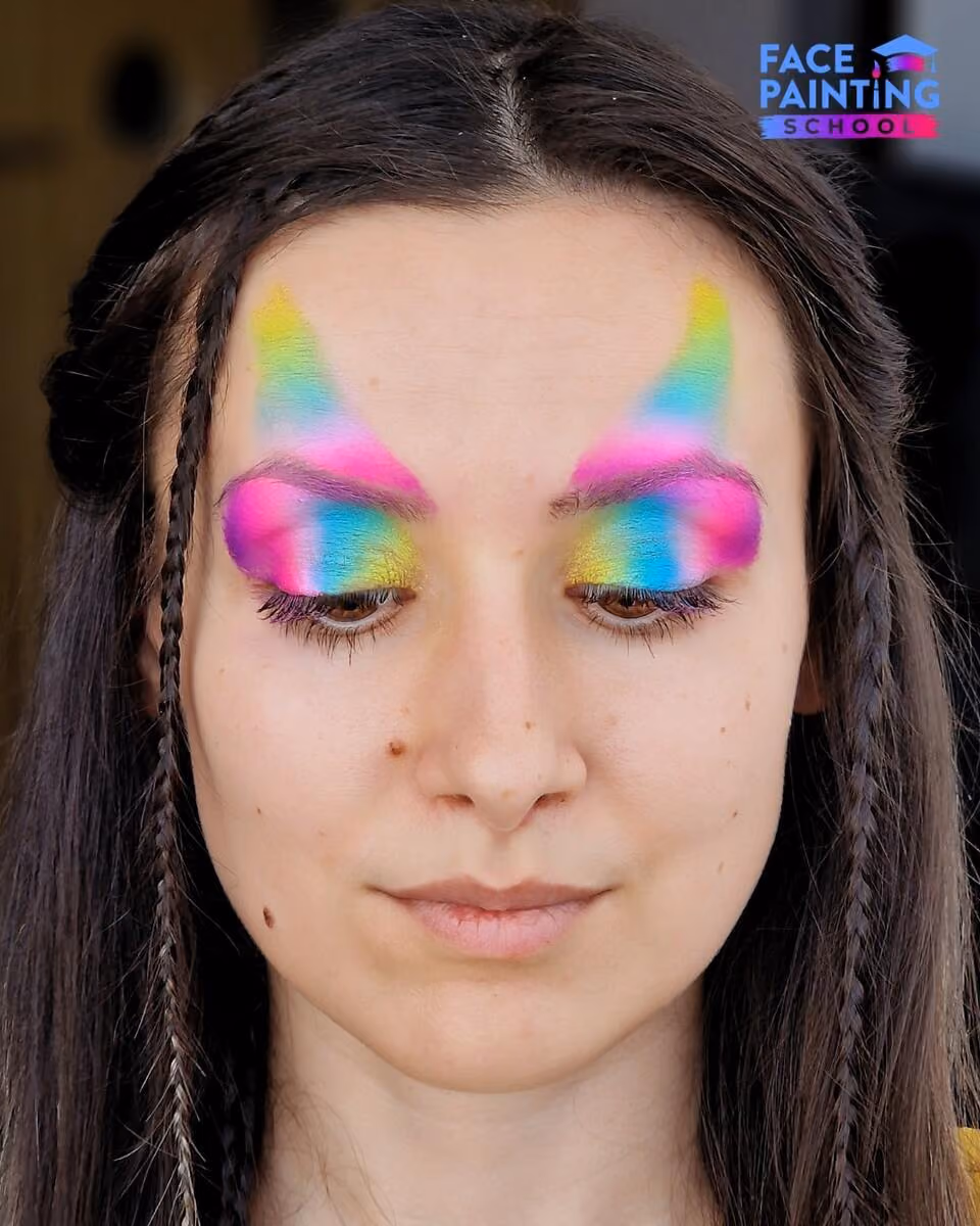 a woman with a shiny rainbow colored paint over her forehead and eyes
